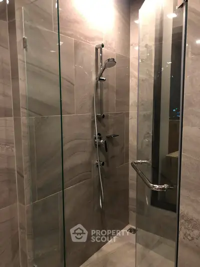 Modern bathroom with sleek glass shower enclosure and elegant tile design.