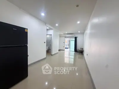 Spacious open-plan living area with sleek tile flooring and modern appliances.
