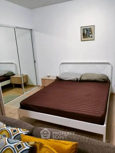 Cozy bedroom with mirrored closet and modern decor in a stylish apartment.