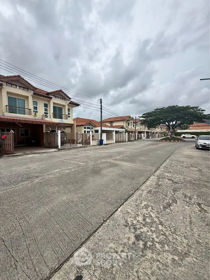 Charming suburban street with modern townhouses and spacious driveways, perfect for family living.