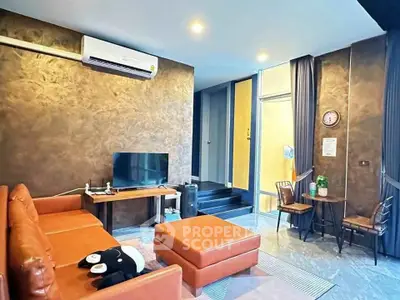 Stylish modern living room with leather sofa and TV, perfect for relaxation.