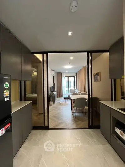 Modern open-layout kitchen leading to a stylish living room with elegant decor and natural light.