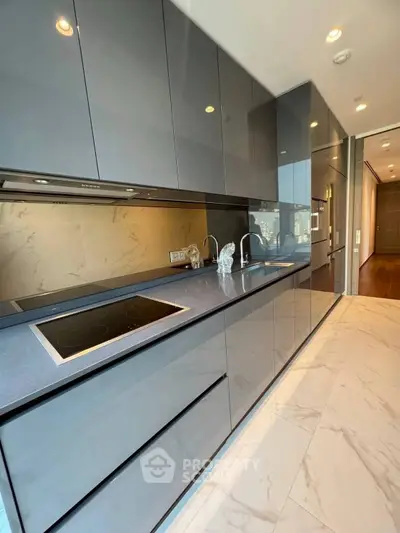 Sleek modern kitchen with glossy cabinets and marble flooring