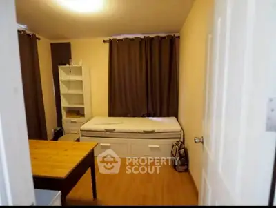 Cozy bedroom with wooden flooring, single bed, and study desk, ideal for a comfortable living space.