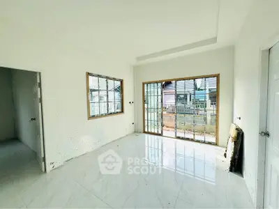 Bright unfurnished room with large windows and white tile flooring