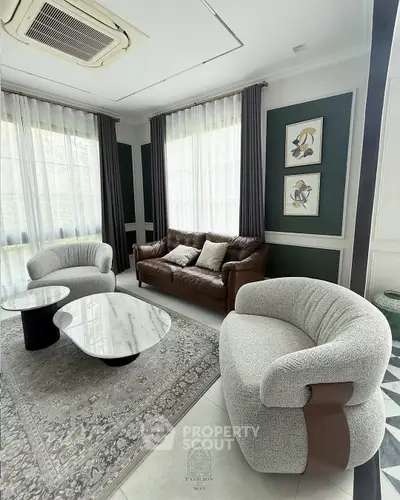 Elegant living room with modern furniture and stylish decor, featuring a cozy seating area and large windows.