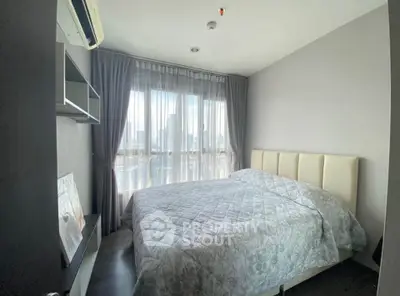 Modern bedroom with city view, featuring a cozy bed and elegant decor, perfect for urban living.