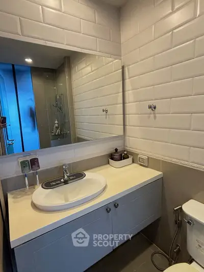 Modern bathroom with sleek vanity and large mirror in contemporary apartment.
