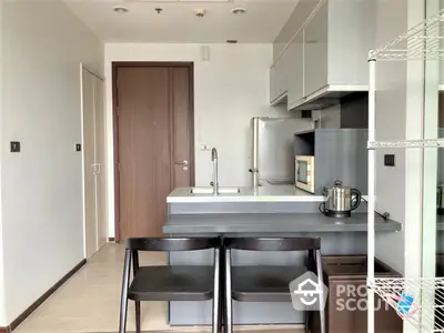 Sleek modern kitchen with stainless steel appliances, ample cabinetry, and a cozy breakfast bar setup, perfect for urban living.