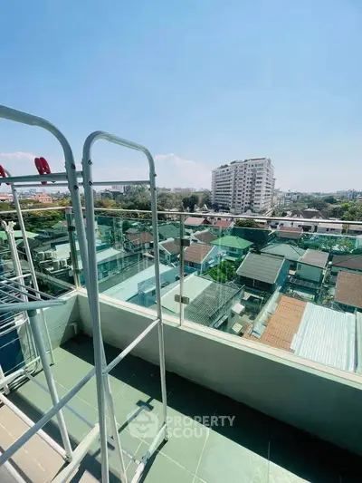 Stunning balcony view with cityscape and clear blue sky, perfect for urban living.