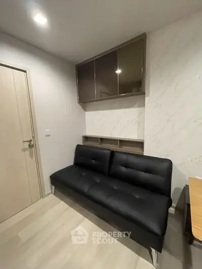 Modern living room with sleek black sofa and stylish wall cabinets