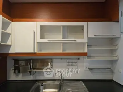 Modern kitchen with sleek cabinetry and stainless steel sink, perfect for culinary enthusiasts.