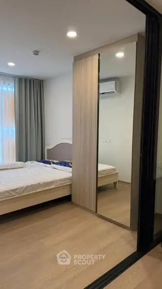 Modern bedroom with mirrored wardrobe and air conditioning in a stylish apartment.
