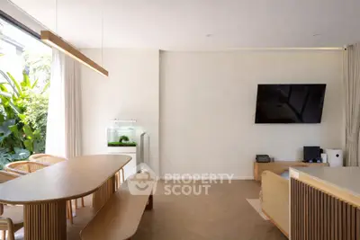 Modern living room with sleek wooden furniture and wall-mounted TV, featuring a large window with garden view.