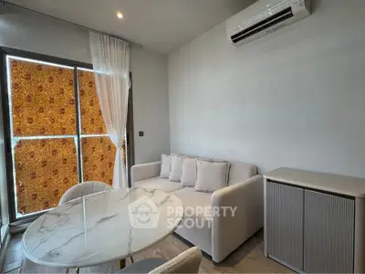 Modern living room with elegant marble table and cozy sofa, featuring air conditioning and stylish decor.