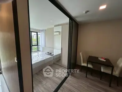 Modern bedroom with large windows and dining area in a stylish apartment.