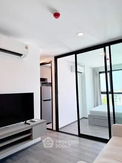 Modern apartment interior with sleek living room and bedroom separation, featuring air conditioning and natural light.