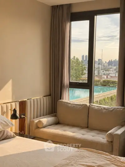 Luxurious bedroom with city view and cozy seating area, perfect for relaxation and comfort.
