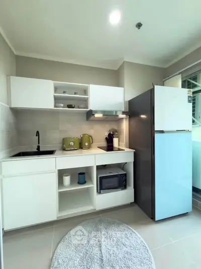 Modern kitchen with sleek white cabinets, stylish appliances, and a cozy open layout.