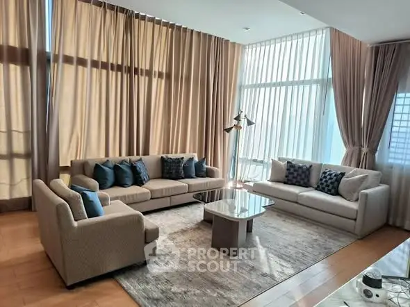 Luxurious living room with elegant sofas and floor-to-ceiling windows