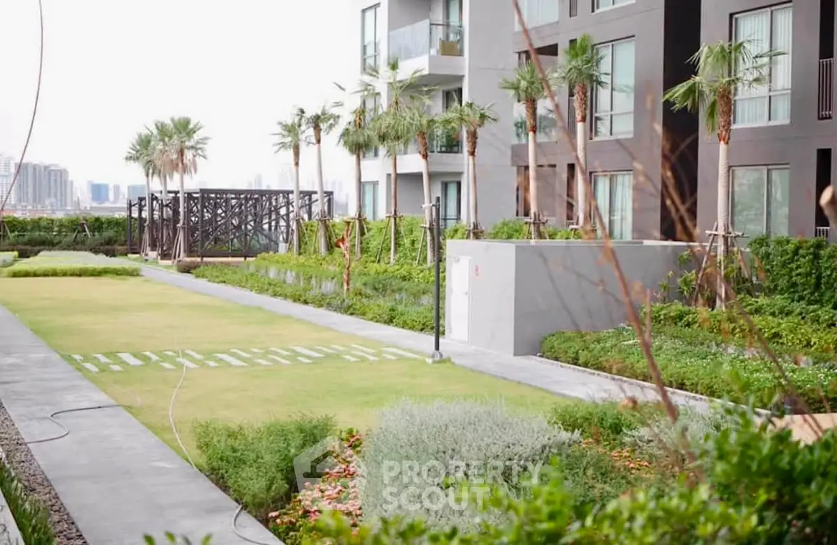 Modern apartment building with lush garden and city view, offering serene urban living.