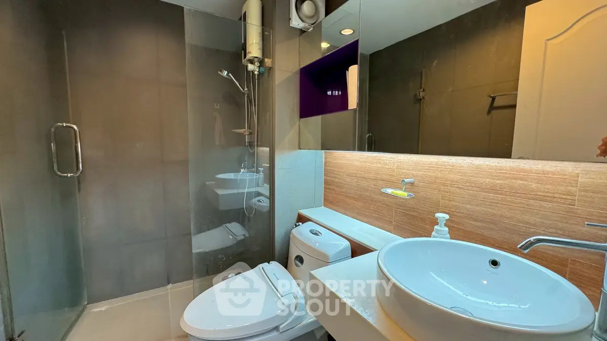Modern bathroom with glass shower and stylish sink in contemporary home.