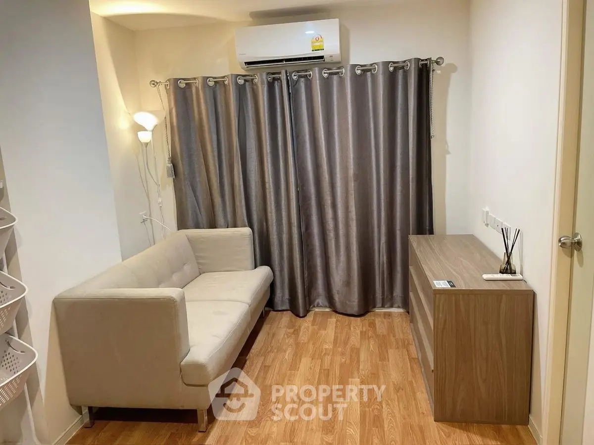 Cozy living room with modern sofa and wooden flooring, ideal for relaxation.