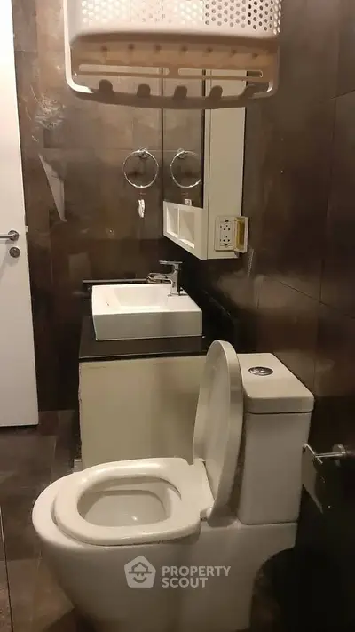 Modern bathroom with sleek fixtures and dark tile design