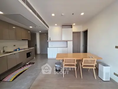 Modern open-layout kitchen and dining area with sleek cabinetry and wooden furniture.