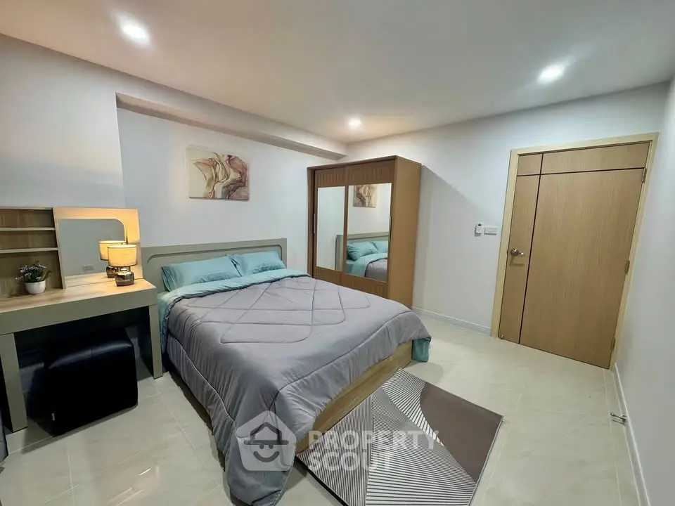 Modern bedroom with stylish decor and ample storage space, featuring a cozy bed and elegant lighting.