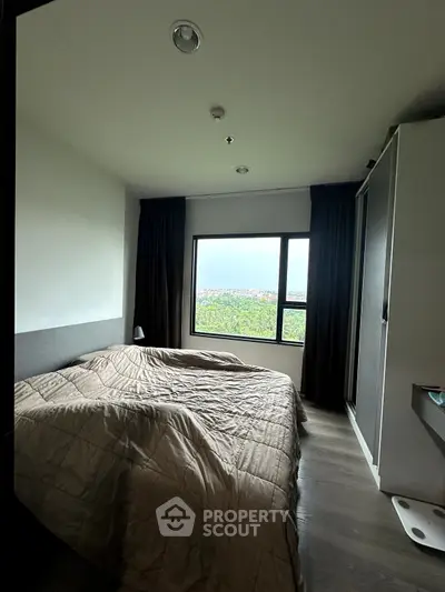 Cozy bedroom with large window offering scenic views and modern furnishings.
