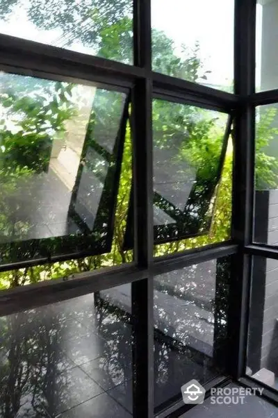 Modern glass window design with lush garden view