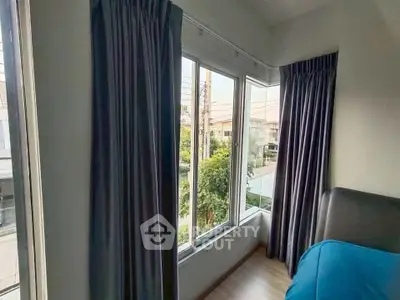 Cozy bedroom corner with large windows and garden view, perfect for natural light lovers.