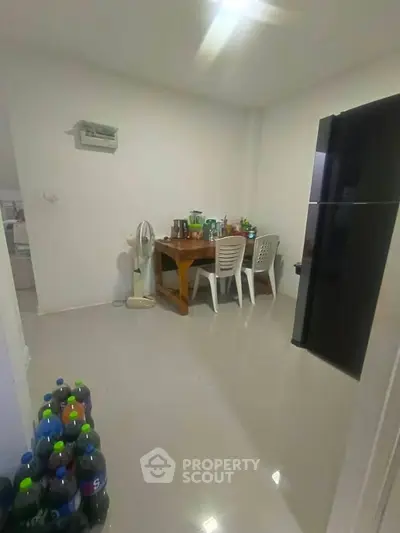 Cozy dining area with modern fridge and sleek tiled flooring, perfect for intimate gatherings.