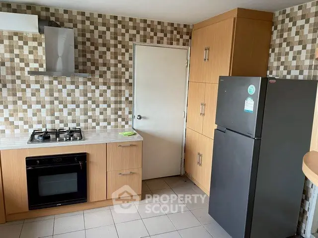 Modern kitchen with gas stove and ample storage in stylish apartment.