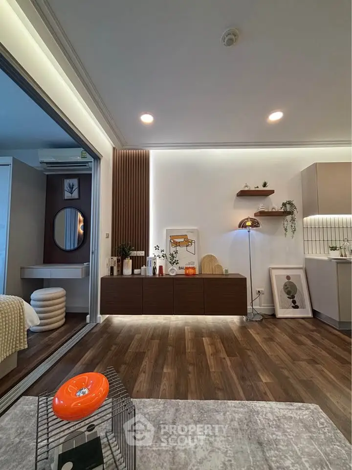 Modern living room with stylish decor and open layout, featuring wooden flooring and contemporary furniture.