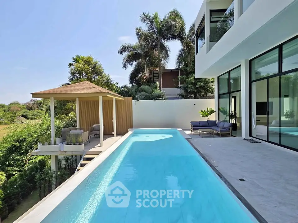 Luxurious modern villa with sleek pool and lush greenery, perfect for relaxation and entertainment.