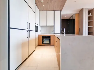 Modern kitchen with sleek cabinetry and built-in oven in luxury apartment