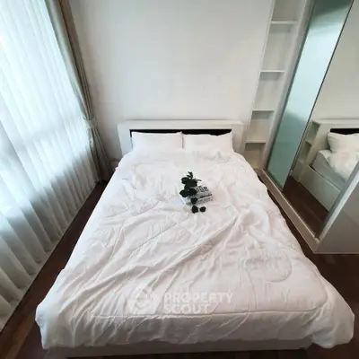 Cozy bedroom with white bedding and mirrored wardrobe, perfect for relaxation.