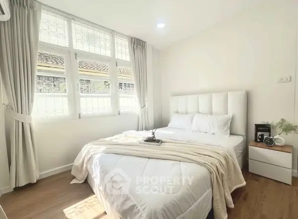 Bright and cozy bedroom with large window and elegant decor