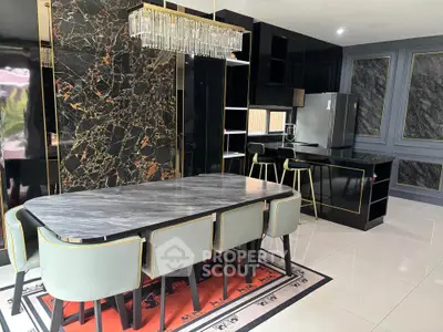Luxurious modern kitchen with marble dining table and elegant black cabinetry.