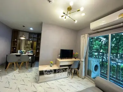 Modern living room with balcony, stylish furniture, and open kitchen layout in a cozy apartment.