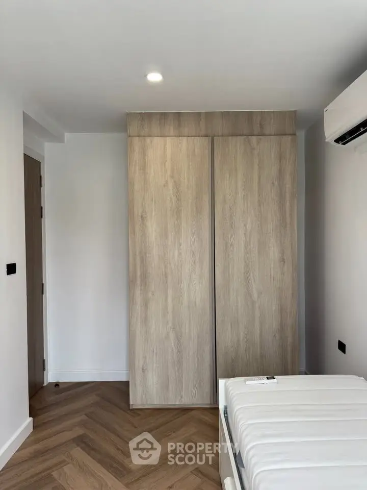 Modern bedroom with wooden wardrobe and air conditioning unit
