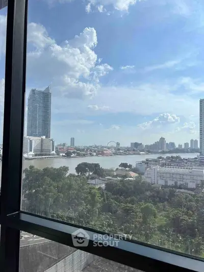 Stunning cityscape view from high-rise window overlooking river and skyline, perfect for urban living.