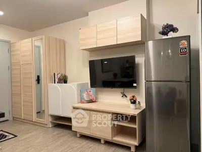 Modern living room with sleek furniture and stainless steel fridge