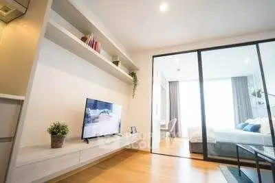 Modern living room with sliding glass doors leading to a bright bedroom