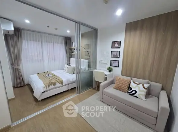 Modern bedroom with glass partition, cozy sofa, and stylish decor