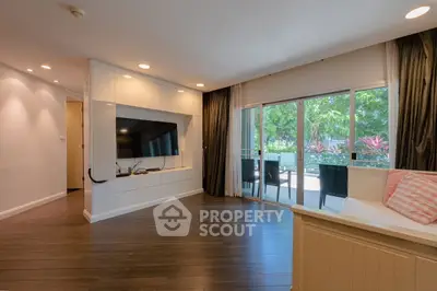 Spacious living room with large TV and garden view, perfect for relaxation.