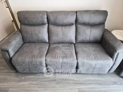 Modern gray sofa in a stylish living room setting with sleek flooring.