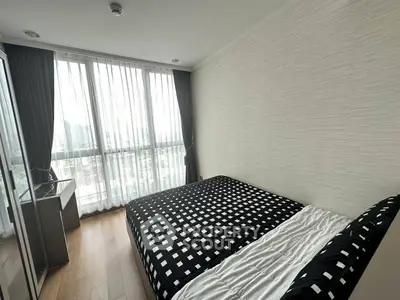 Modern bedroom with large windows and stylish decor in a high-rise apartment.